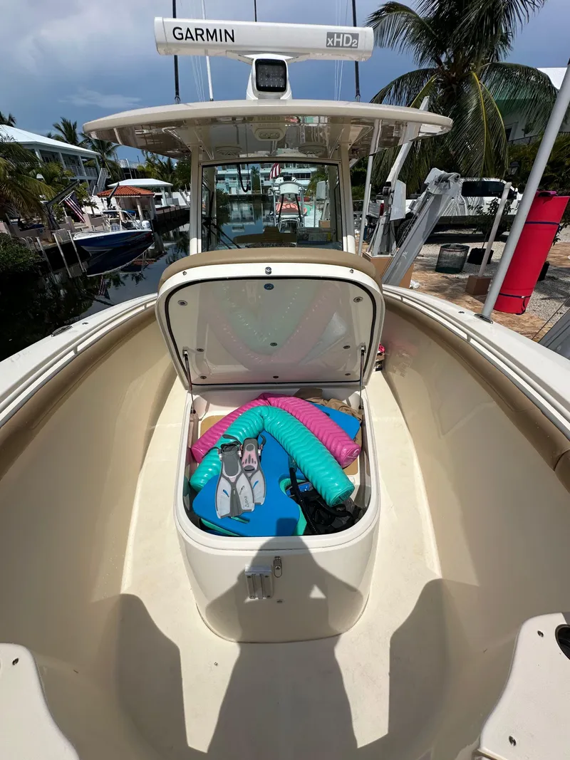 Slide: The Image of 2018 Scout 300 LXF boat with open storage compartment, pool noodles, and life jackets. - 17