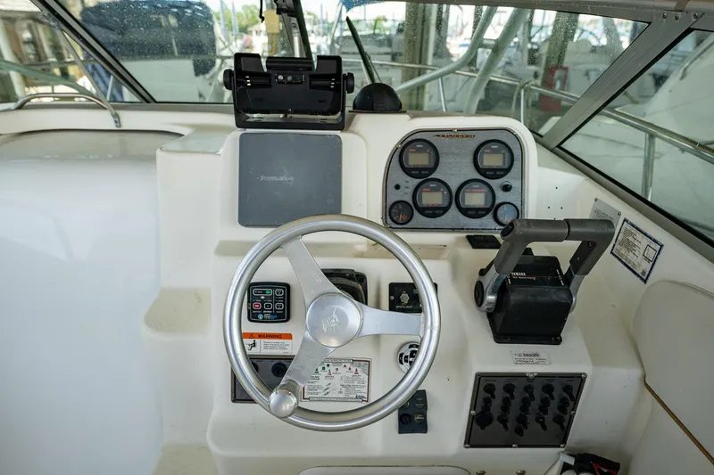 Slide: The Image of 2003 Aquasport 275 Explorer boat helm with steering wheel and control panel. - 14