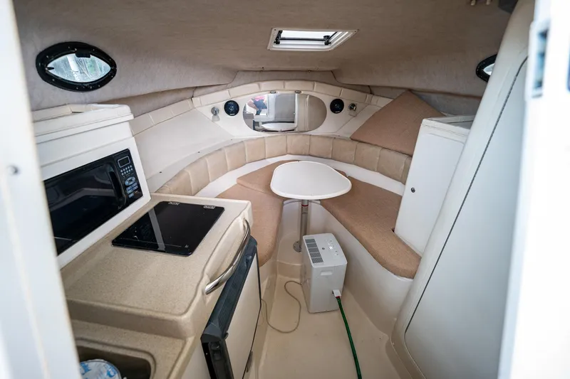 Slide: The Image of Interior cabin of a 2003 Aquasport 275 Explorer boat with kitchenette and seating area. - 19