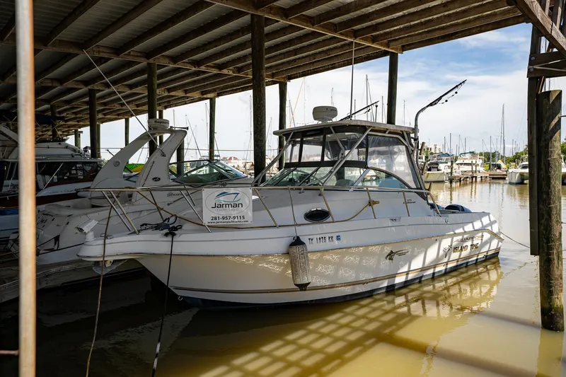 Slide: The Image of 2003 Aquasport 275 Explorer docked in a covered marina. - 2