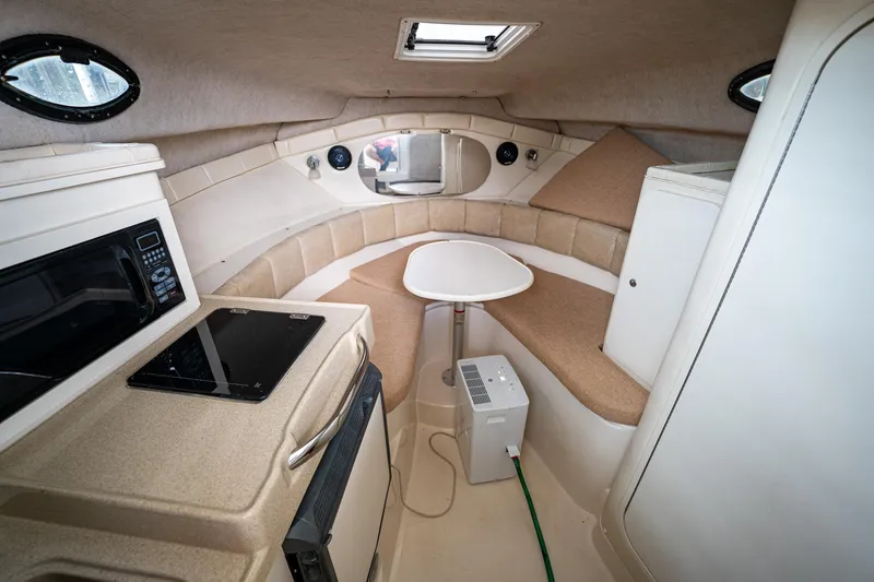 Slide: The Image of 2003 Aquasport 275 Explorer cabin interior with kitchenette and seating area. - 21