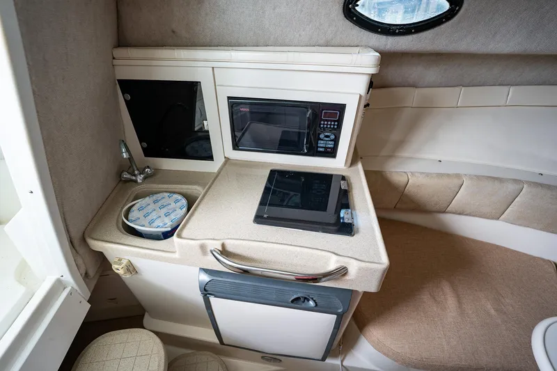 Slide: The Image of Compact kitchenette in 2003 Aquasport 275 Explorer boat with microwave, sink, and storage. - 22