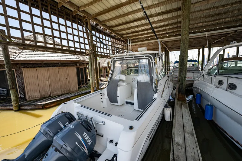 Slide: The Image of 2003 Aquasport 275 Explorer boat docked under a covered marina. - 8
