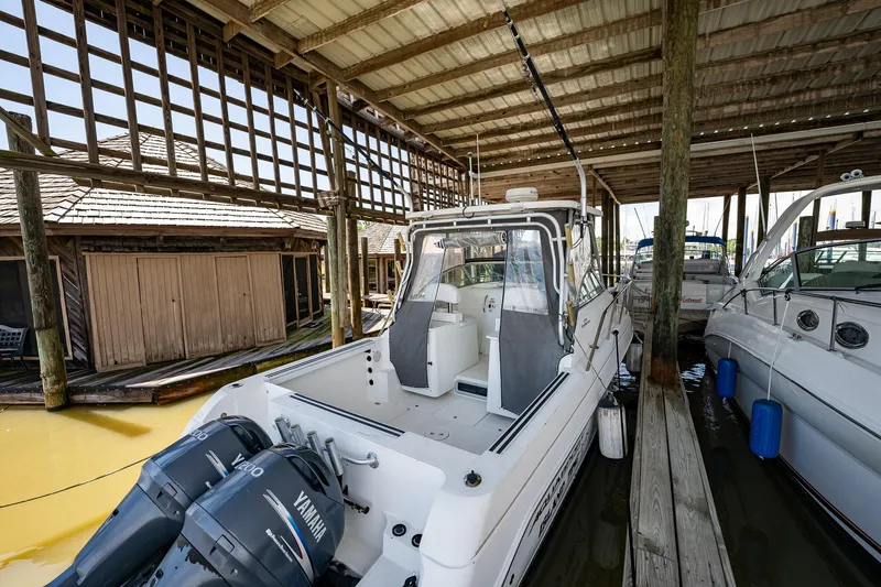 Slide: The Image of 2003 Aquasport 275 Explorer boat docked under a covered marina. - 9