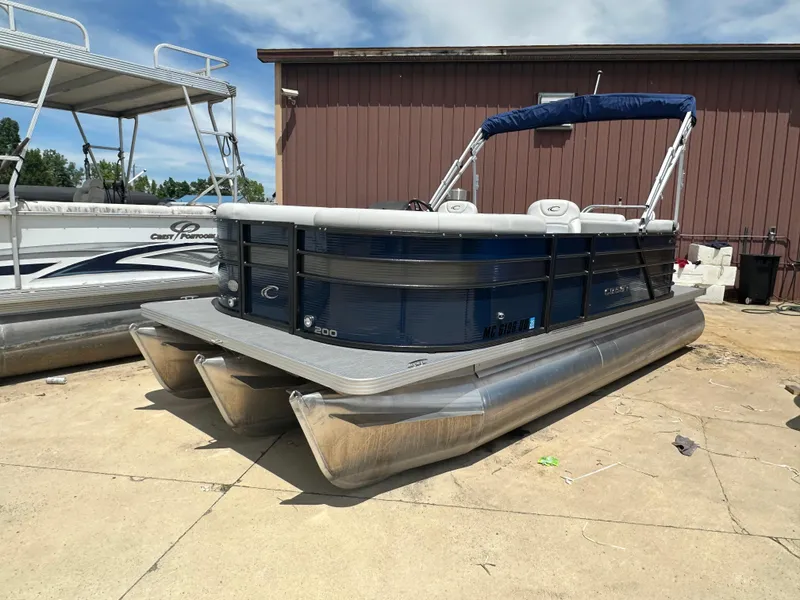 The Image of 2022 Crest Classic DLX 200 SLC pontoon boat docked on concrete. - 0