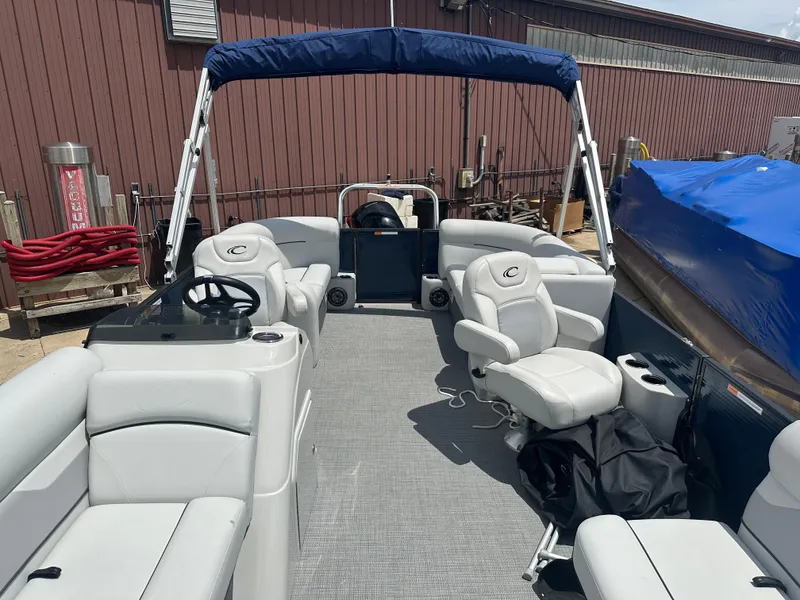 Slide: The Image of 2022 Crest Classic DLX 200 SLC pontoon boat with blue canopy and white seating. - 2