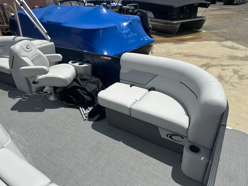 Slide: The Image of 2022 Crest Classic DLX 200 SLC pontoon boat with gray seating and blue cover. - 3