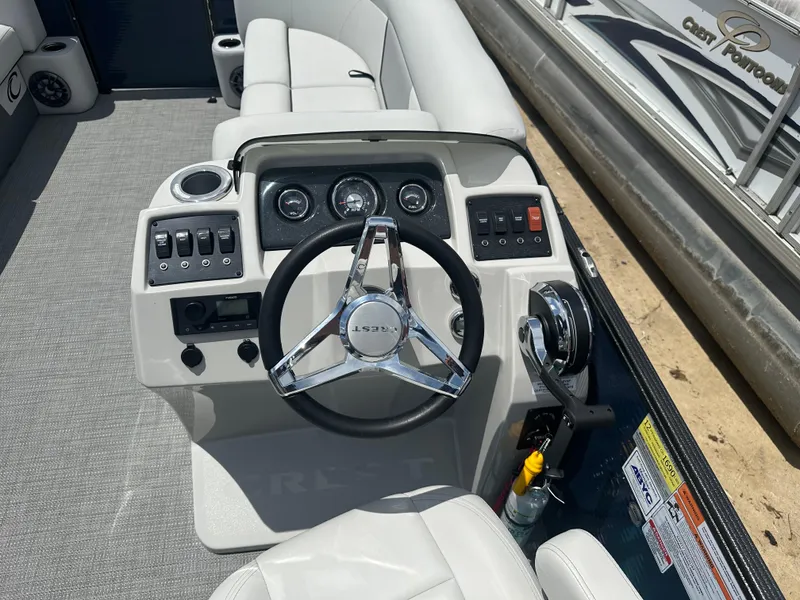 Slide: The Image of 2022 Crest Classic DLX 200 SLC boat dashboard with steering wheel and control panel. - 7