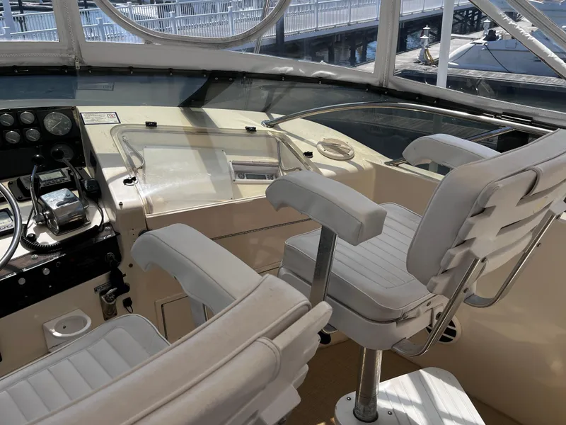 Slide: The Image of Cockpit of 1991 Hatteras 52 Cockpit Motoryacht with white seating and control panel. - 10