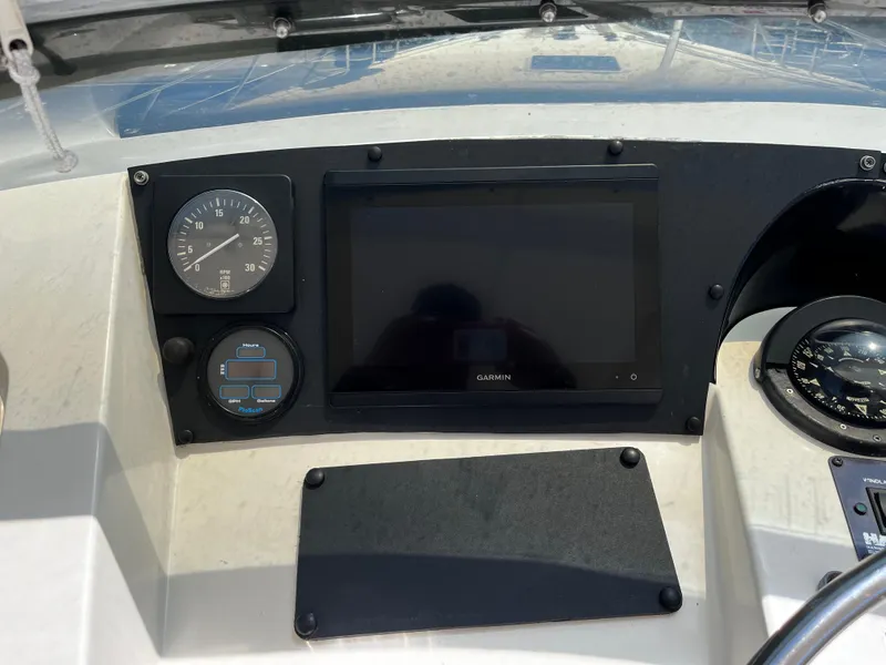 Slide: The Image of 1991 Hatteras 52 Cockpit Motoryacht dashboard with Garmin display and compass. - 11
