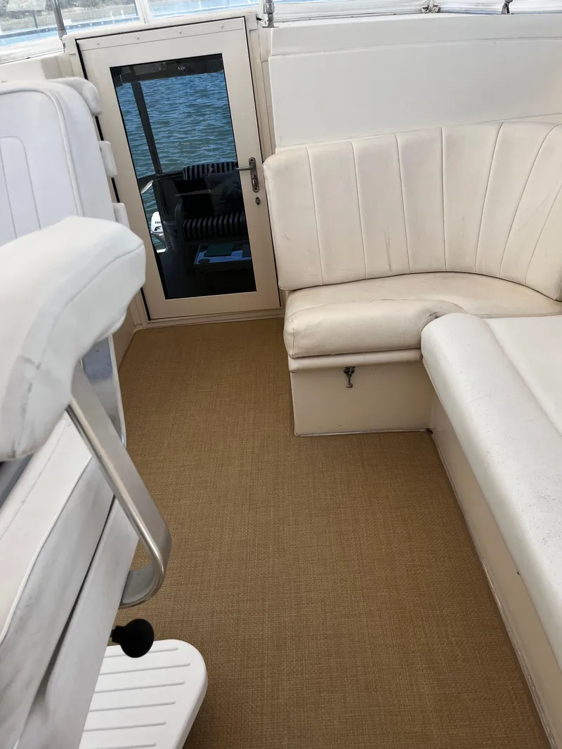 Slide: The Image of 1991 Hatteras 52 Cockpit Motoryacht interior with white seating and beige carpet. - 19