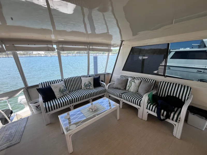 Slide: The Image of Interior of 1991 Hatteras 52 Cockpit Motoryacht with striped seating and water view. - 26