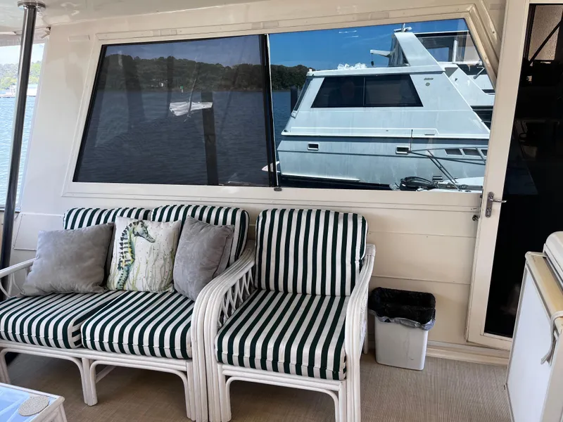 Slide: The Image of Interior of 1991 Hatteras 52 Cockpit Motoryacht with striped seating and scenic window view. - 27