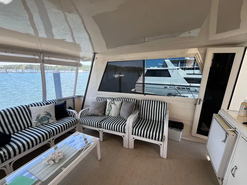 Slide: The Image of Interior of 1991 Hatteras 52 Cockpit Motoryacht with striped seating and waterfront view. - 28