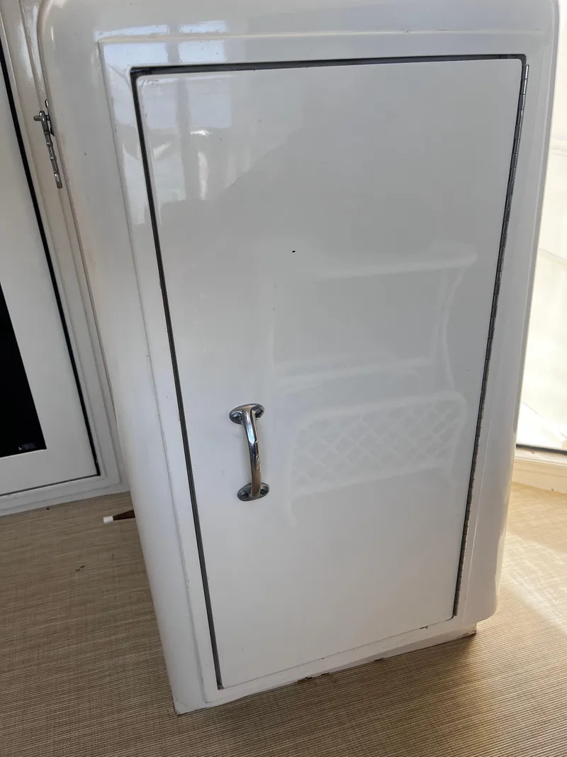 Slide: The Image of White storage compartment on 1991 Hatteras 52 Cockpit Motoryacht with chrome handle. - 29