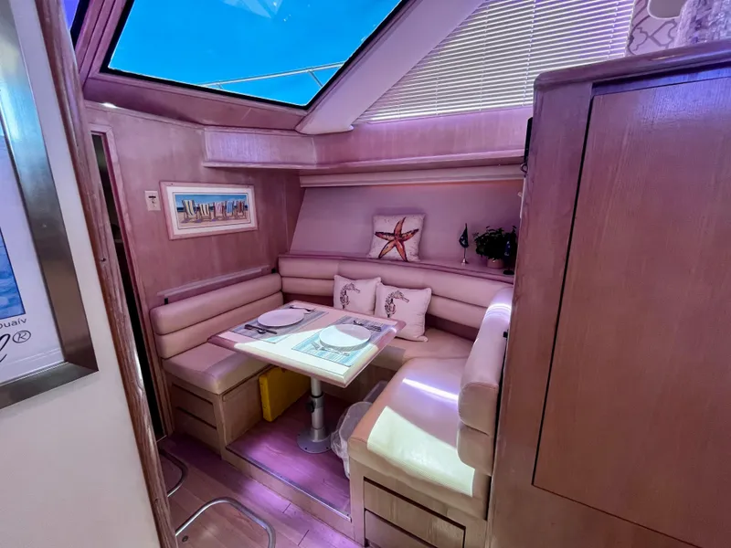 Slide: The Image of Luxurious 1991 Hatteras 52 Cockpit Motoryacht interior with cozy dining area and skylight. - 31