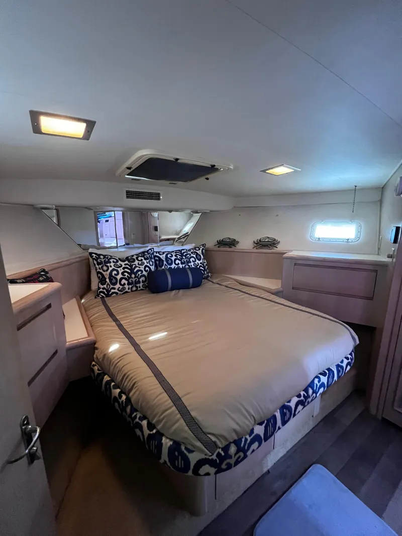 Slide: The Image of Luxurious bedroom in 1991 Hatteras 52 Cockpit Motoryacht with elegant bedding and modern lighting. - 38