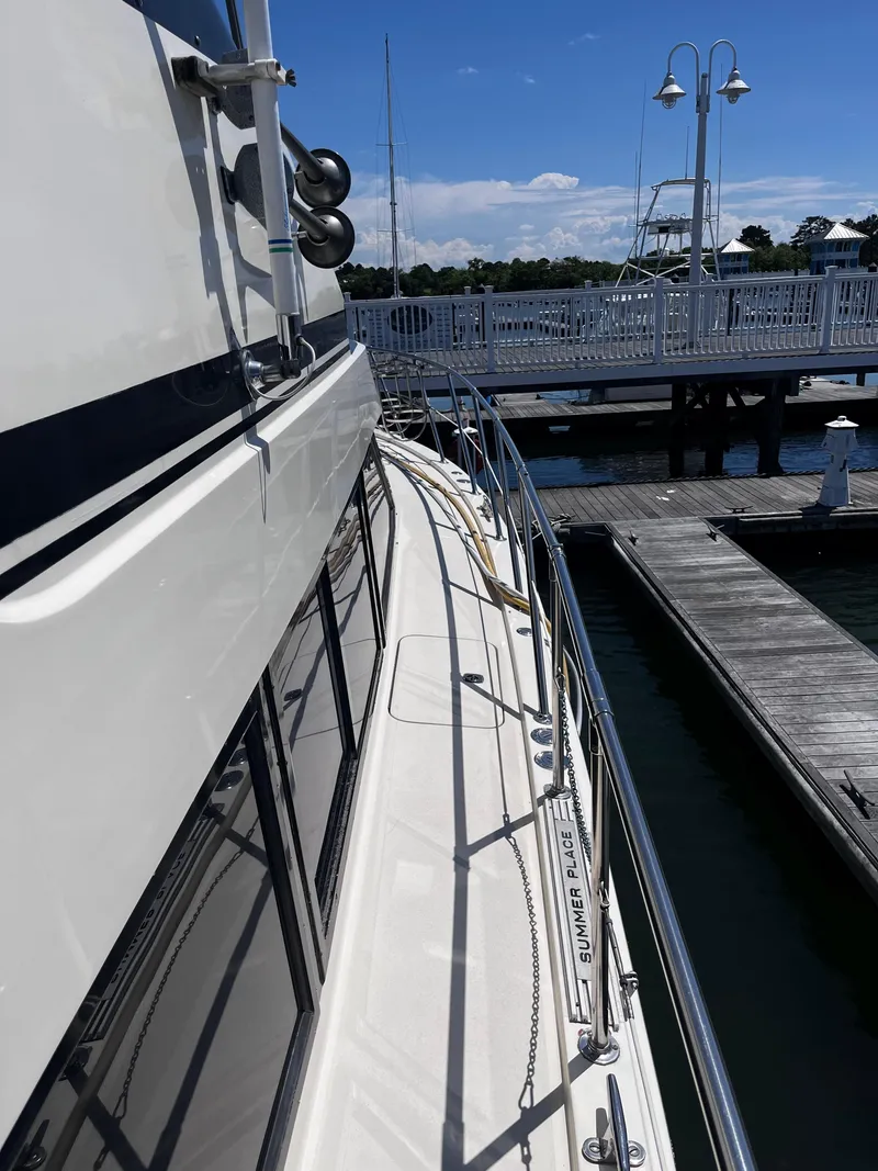 Slide: The Image of 1991 Hatteras 52 Cockpit Motoryacht docked at marina under clear blue sky. - 4