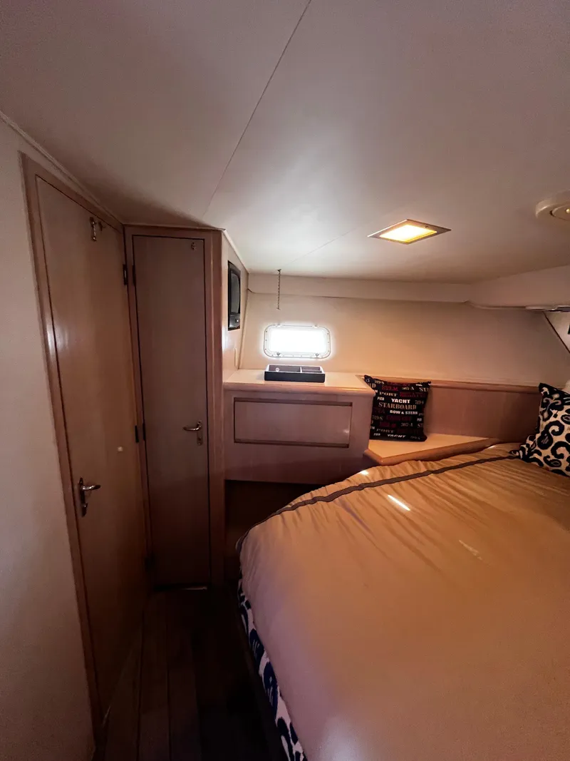 Slide: The Image of 1991 Hatteras 52 Cockpit Motoryacht bedroom with cozy bed and wooden cabinetry. - 40