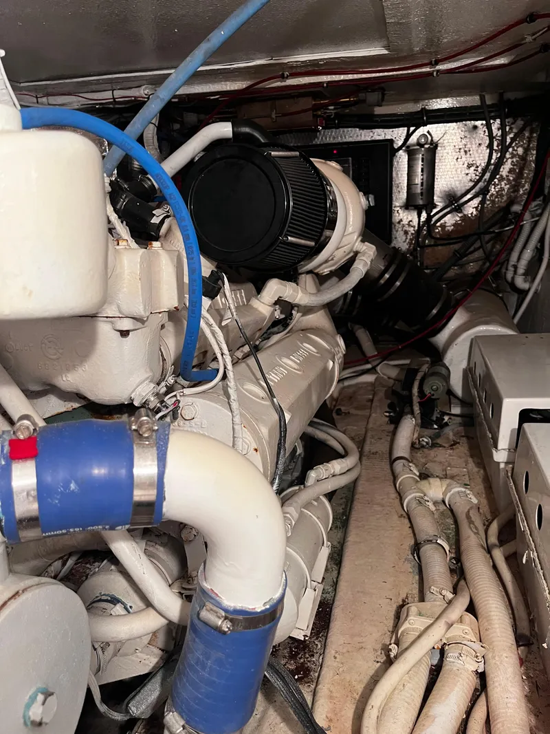 Slide: The Image of Engine room of a 1991 Hatteras 52 Cockpit Motoryacht, showcasing mechanical components. - 49