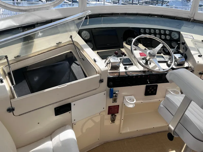 Slide: The Image of 1991 Hatteras 52 Cockpit Motoryacht helm with steering wheel and control panel. - 9