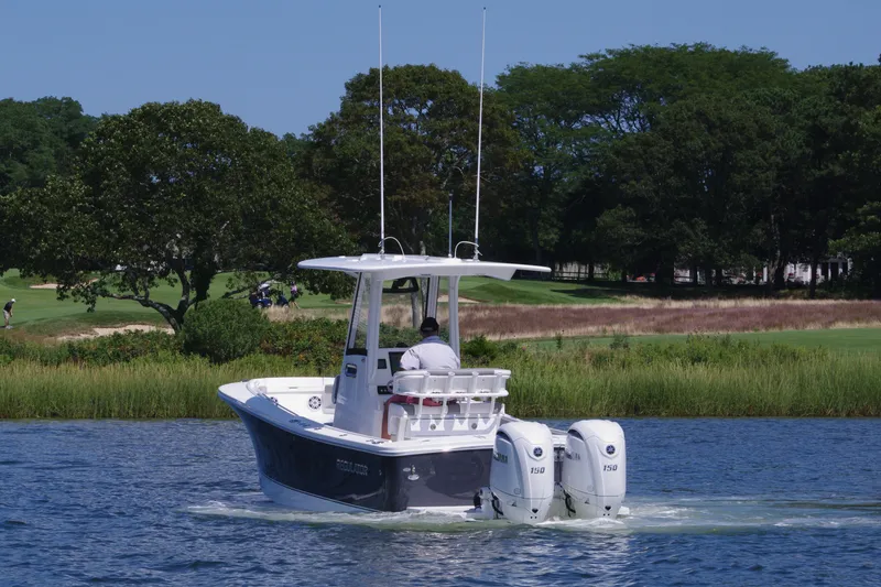 Slide: The Image of 2024 Regulator 23 boat cruising on a scenic lake with lush greenery. - 10