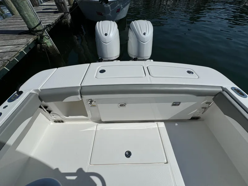 Slide: The Image of 2024 Regulator 23 boat with dual outboard engines docked by the water. - 16