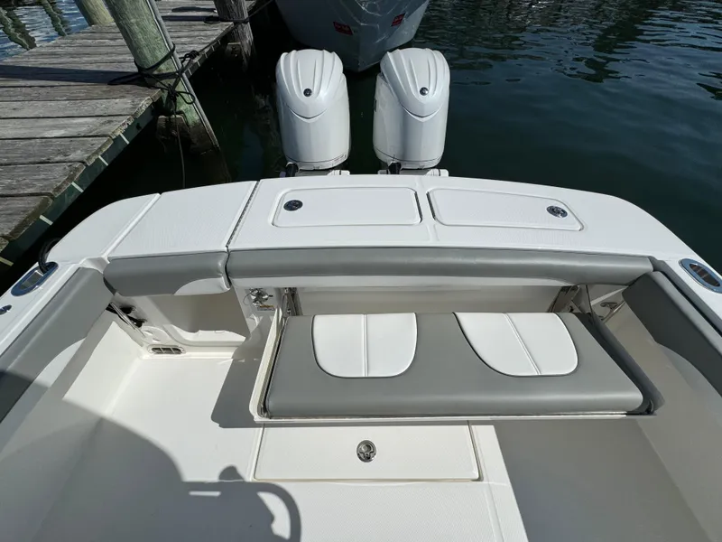 Slide: The Image of 2024 Regulator 23 boat with dual engines and cushioned seating at the dock. - 17