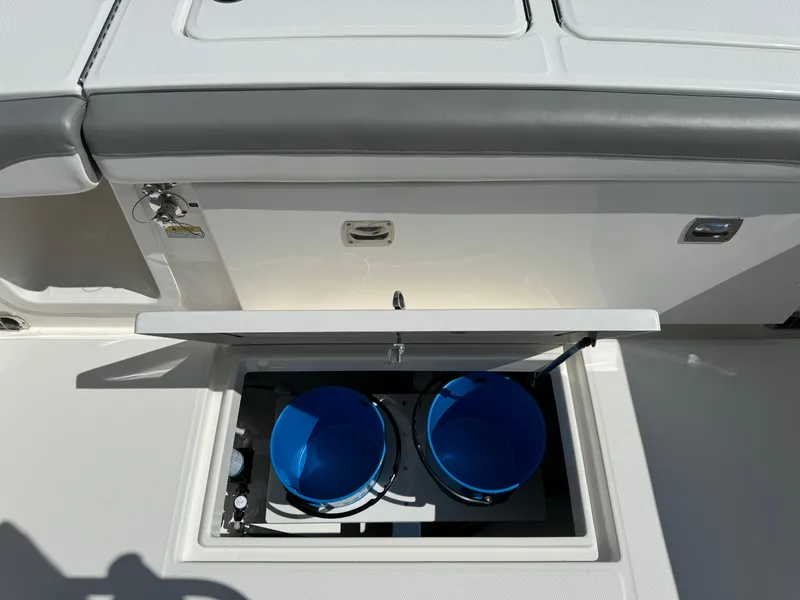 Slide: The Image of 2024 Regulator 23 boat storage compartment with blue containers. - 18