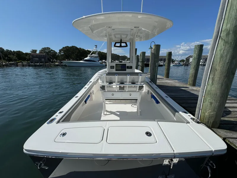 Slide: The Image of 2024 Regulator 23 boat docked, featuring spacious deck and modern design. - 19