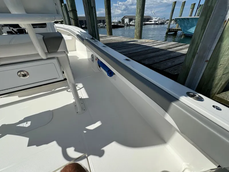 Slide: The Image of 2024 Regulator 23 boat interior at a dock, showcasing seating and storage. - 23