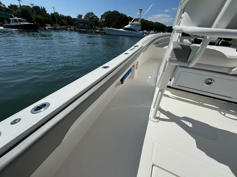 Slide: The Image of 2024 Regulator 23 boat interior with seating, docked on a sunny day. - 24