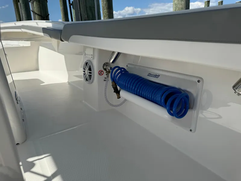 Slide: The Image of 2024 Regulator 23 boat interior with coiled blue hose and speaker. - 26