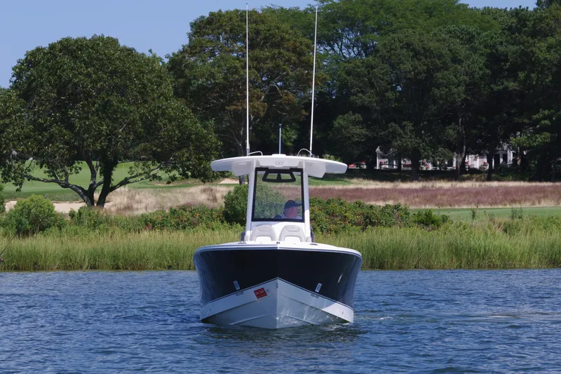 Slide: The Image of 2024 Regulator 23 boat on calm water with lush green background. - 3