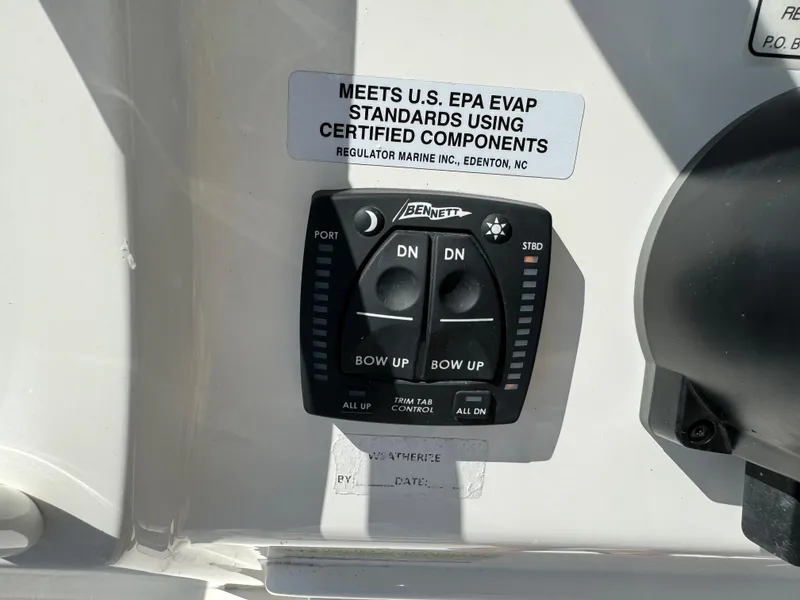 Slide: The Image of 2024 Regulator 23 boat trim tab control panel with EPA compliance label. - 32