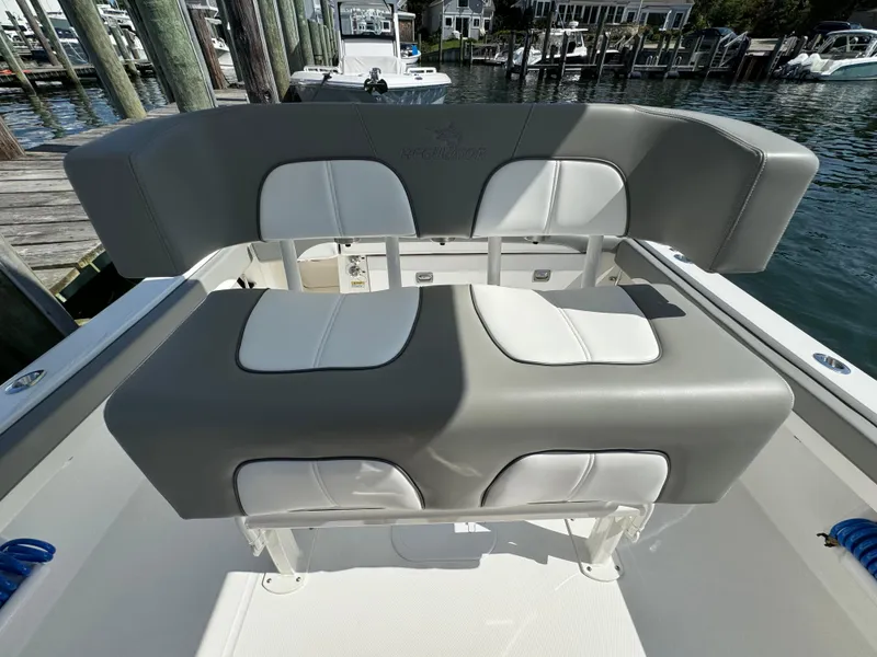 Slide: The Image of 2024 Regulator 23 boat seating, gray and white upholstery, docked at marina. - 36