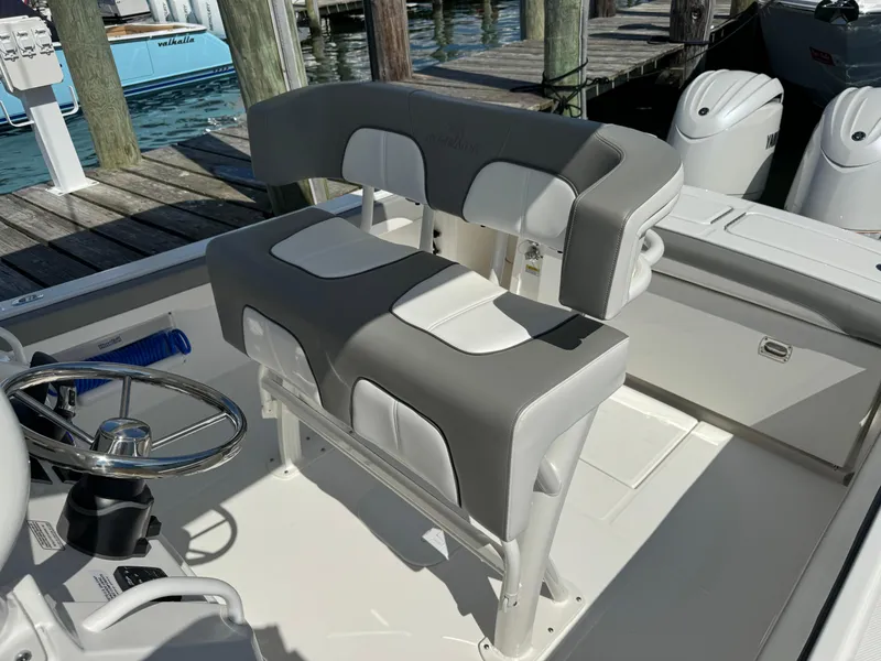 Slide: The Image of 2024 Regulator 23 boat interior with cushioned seating and steering wheel at dock. - 37