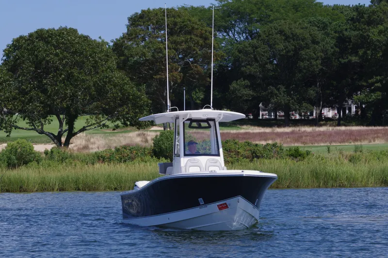 Slide: The Image of 2024 Regulator 23 boat on water with lush green background. - 4