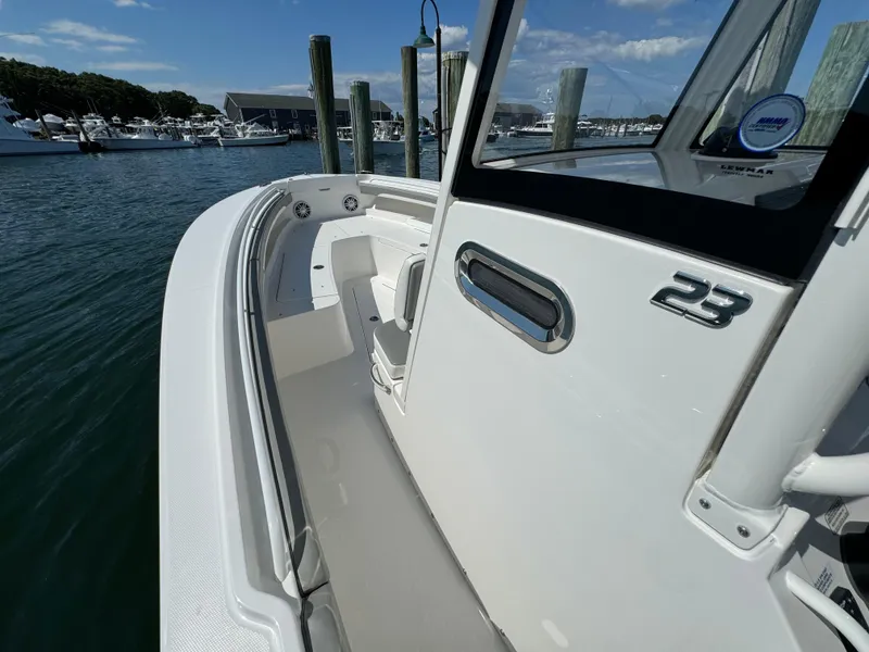 Slide: The Image of 2024 Regulator 23 boat docked at marina, showcasing sleek design and spacious deck. - 40