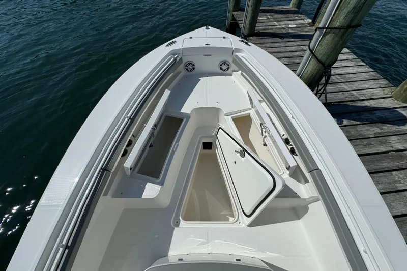 Slide: The Image of 2024 Regulator 23 boat bow with open storage compartments at dock. - 43