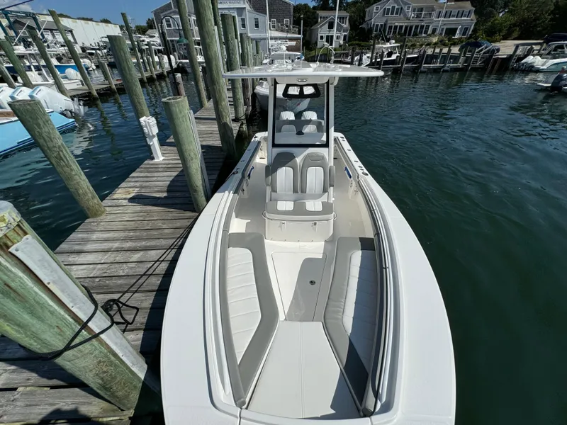 Slide: The Image of 2024 Regulator 23 boat docked at marina, showcasing sleek design and spacious seating. - 46