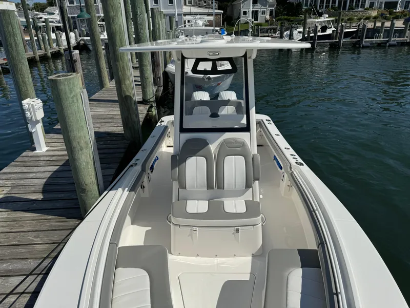Slide: The Image of 2024 Regulator 23 boat docked at marina, featuring spacious seating and modern design. - 47