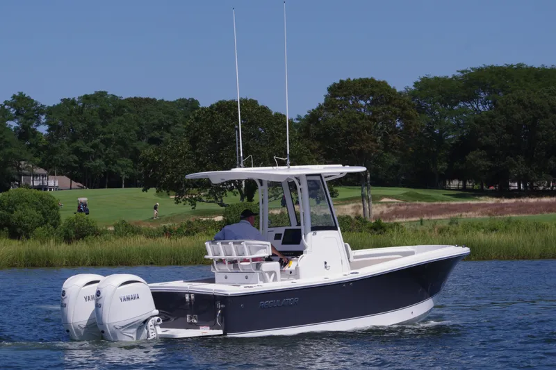 Slide: The Image of 2024 Regulator 23 boat with dual Yamaha engines on a scenic waterway. - 7