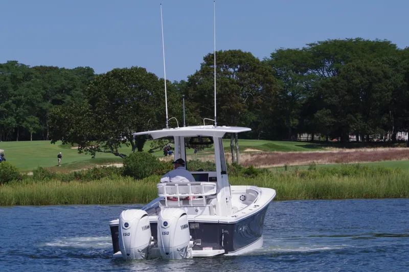 Slide: The Image of 2024 Regulator 23 boat with dual Yamaha engines on a scenic waterway. - 8