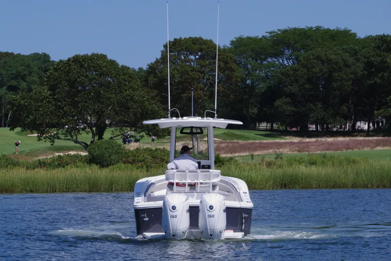 Slide: The Image of 2024 Regulator 23 boat cruising on a scenic lake with lush greenery. - 9