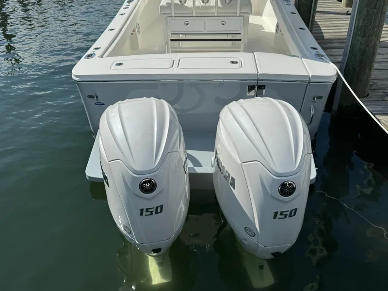 Slide: The Image of 2024 Regulator 23 boat with twin 150 horsepower engines docked in water. - 10