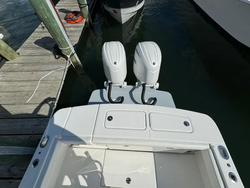 Slide: The Image of 2024 Regulator 23 boat with dual outboard motors docked at a marina. - 13