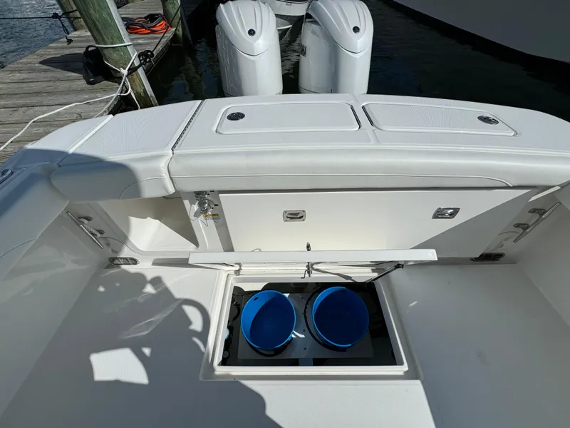 Slide: The Image of 2024 Regulator 23 boat with open storage compartment and twin outboard motors. - 16