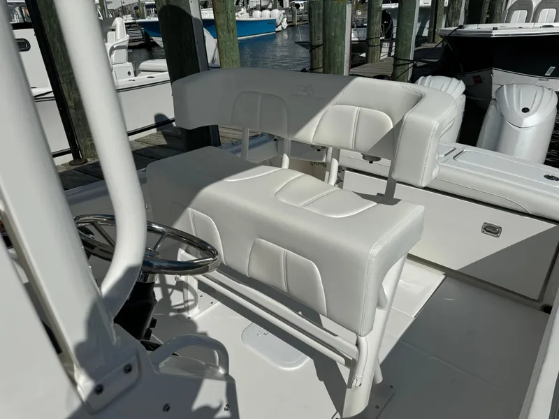 Slide: The Image of 2024 Regulator 23 boat interior with white seating and steering wheel. - 23