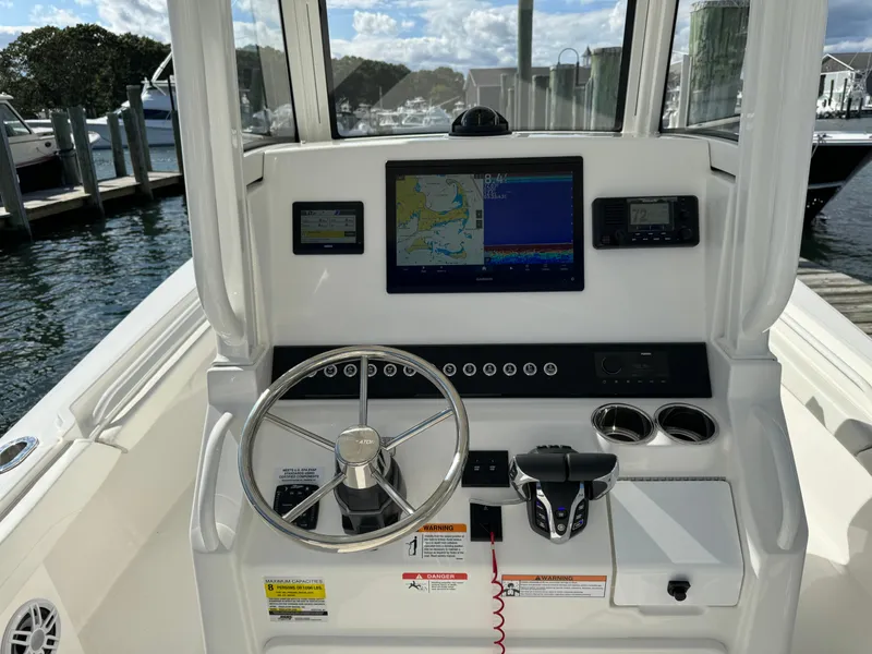 Slide: The Image of 2024 Regulator 23 boat dashboard with navigation screens and steering wheel. - 27